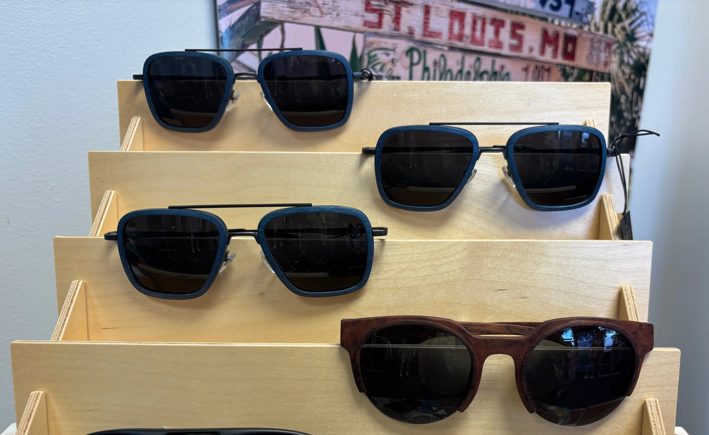 Sunglasses displayed on a wooden rack with a blurred background