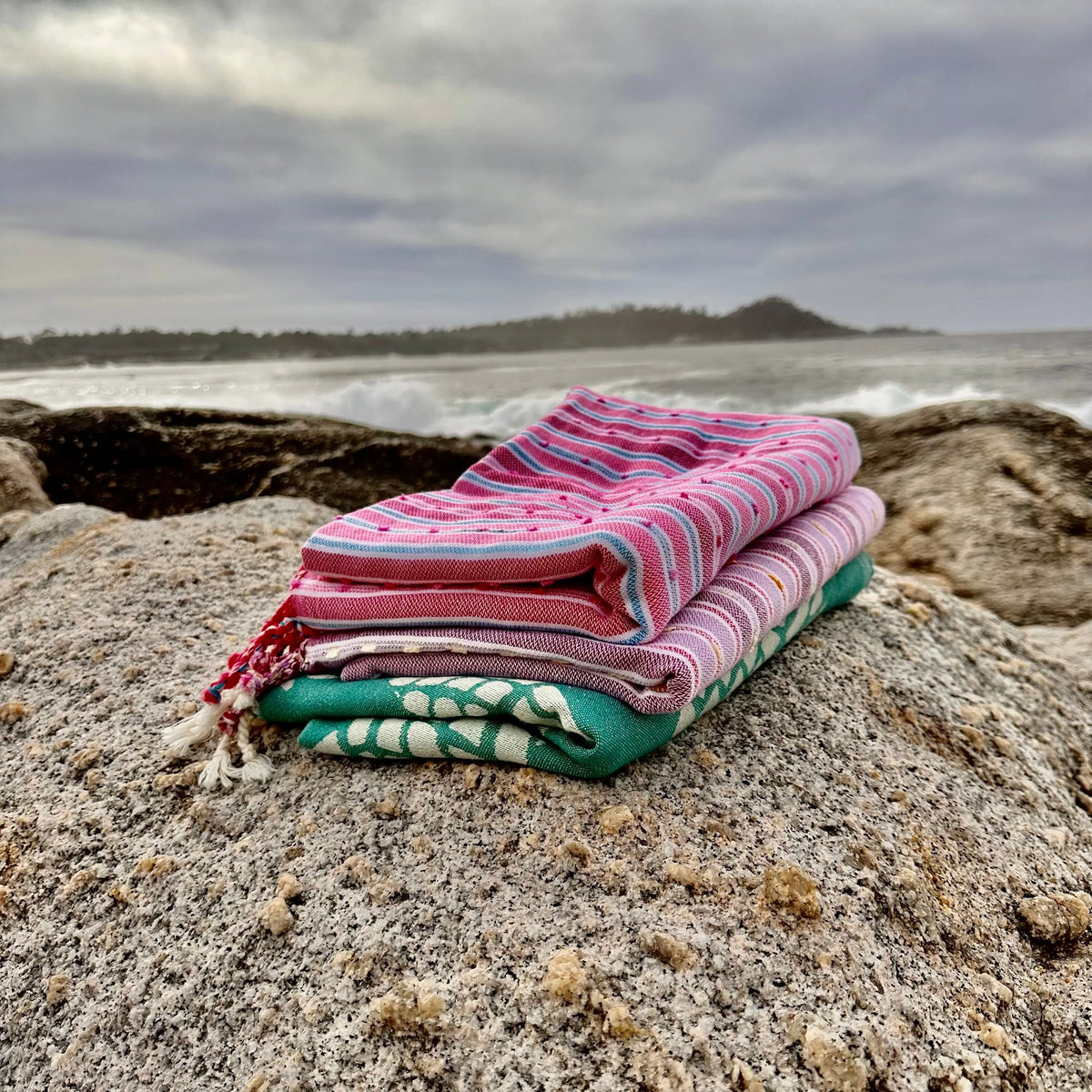 folded stack of towels on sandy beach