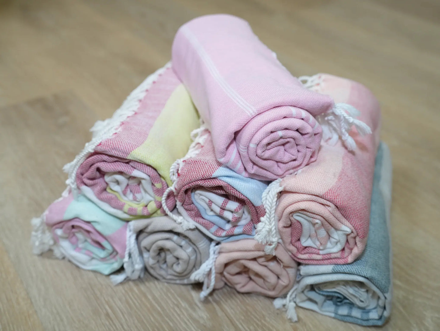a pyramid of rolled towels on a wood surface