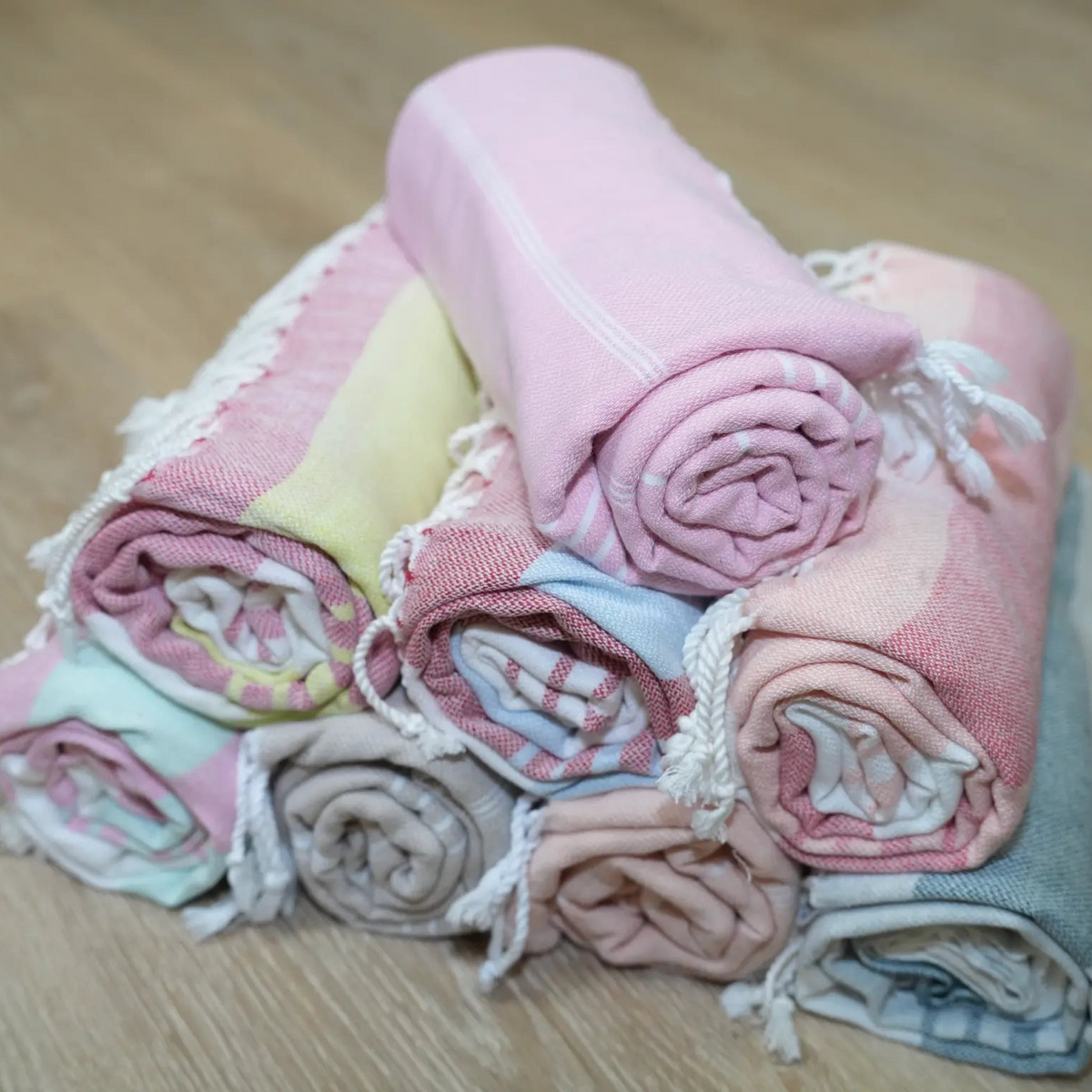 a pyramid of rolled towels on a wood surface