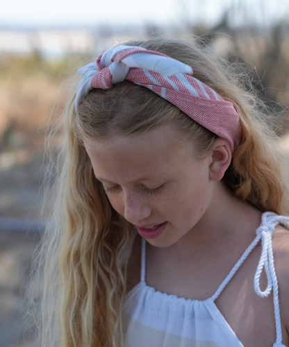 red, blue and white striped bandana being worn as a headband on a young girl