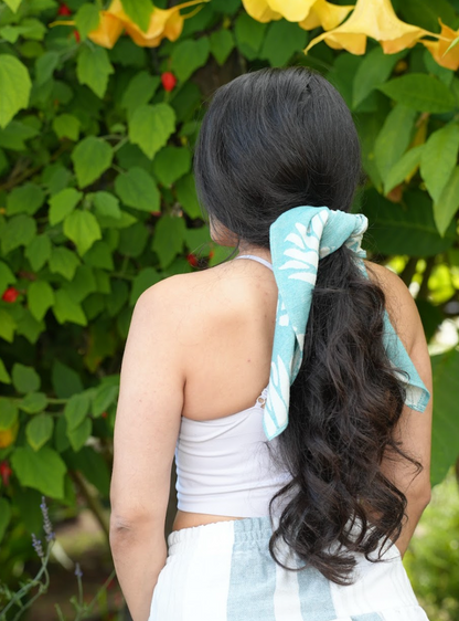 Green pineapple print bandana being worn as a hair tie for long hair