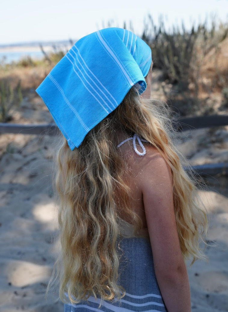 A person wearing a blue striped bandana as a headband.