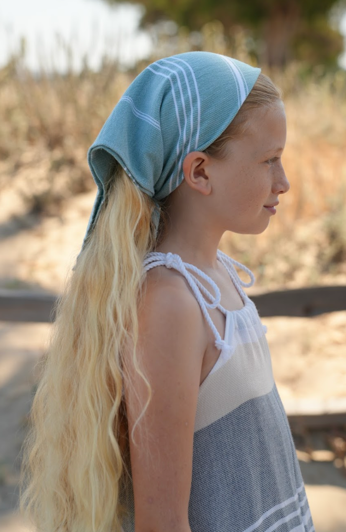 Green striped bandana being worn as a headband on young girl