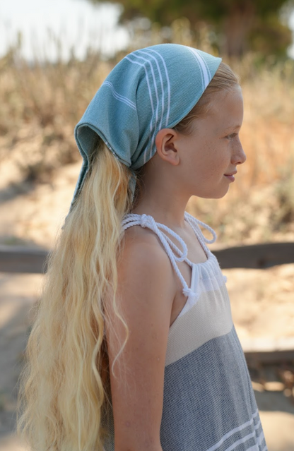 Green striped bandana being worn as a headband on young girl