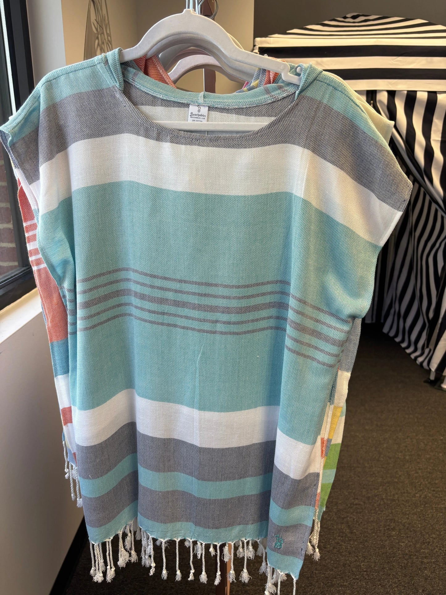 hooded poncho on a hanger with turquoise, charcoal and white stripes