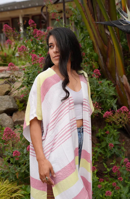 Woman wearing a colorful red, yellow and white striped shawl in a garden setting