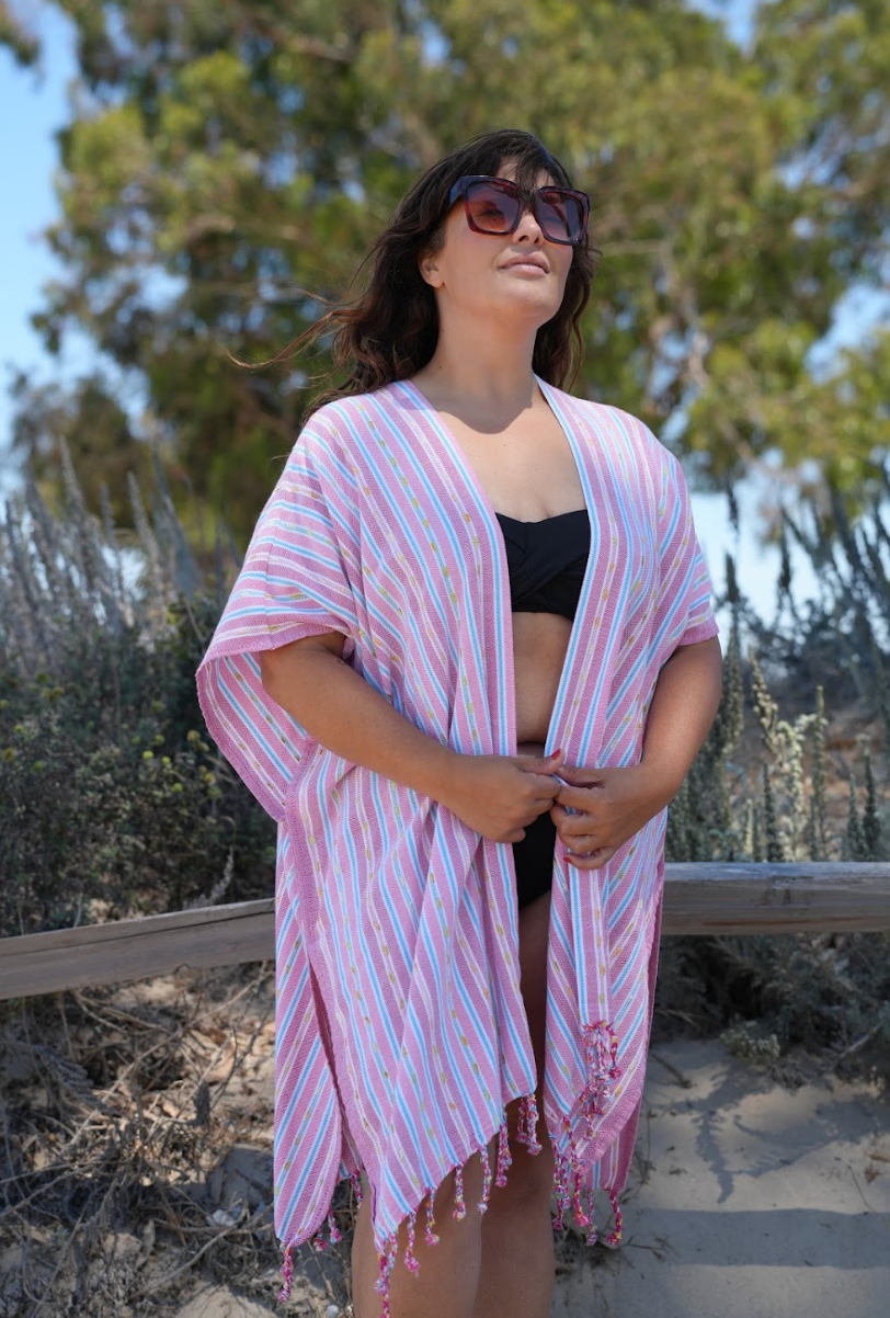 Woman in pink stripe mid-length cover-up in outdoor setting