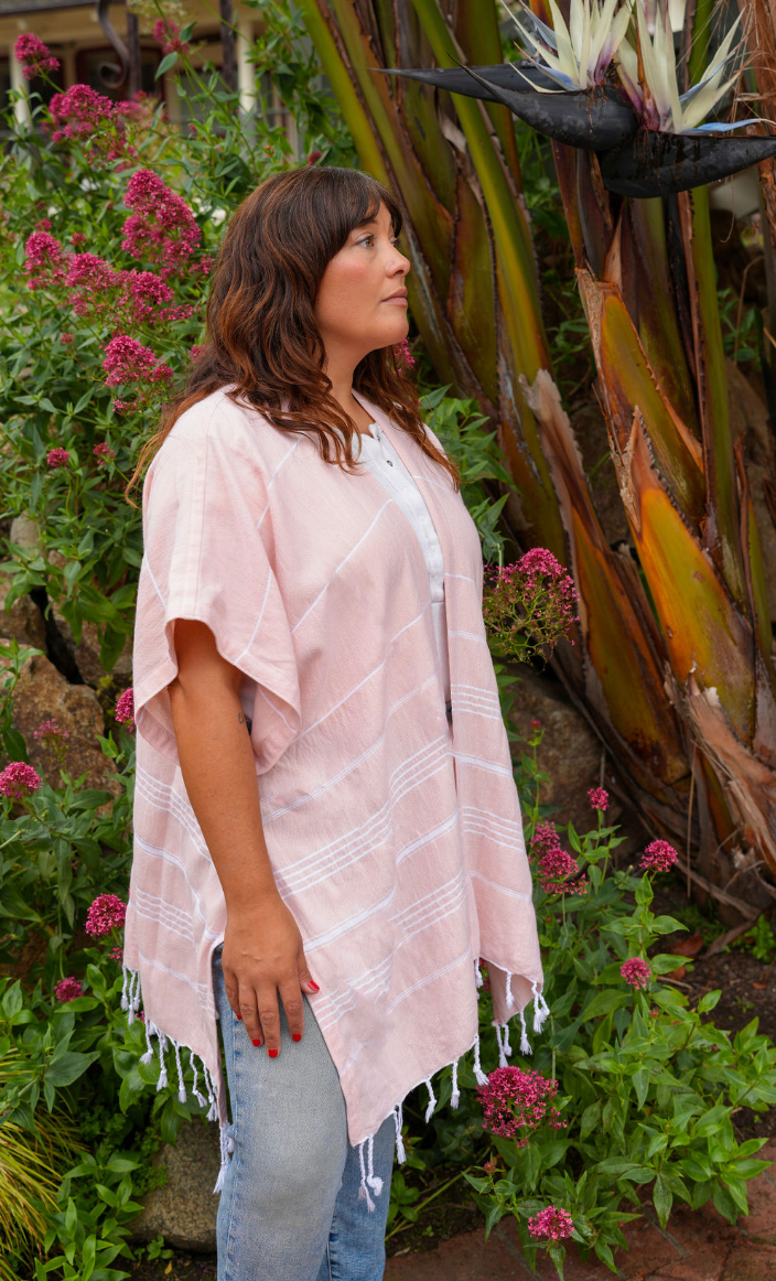 Woman in peach stripe mid-length cover-up in outdoor setting