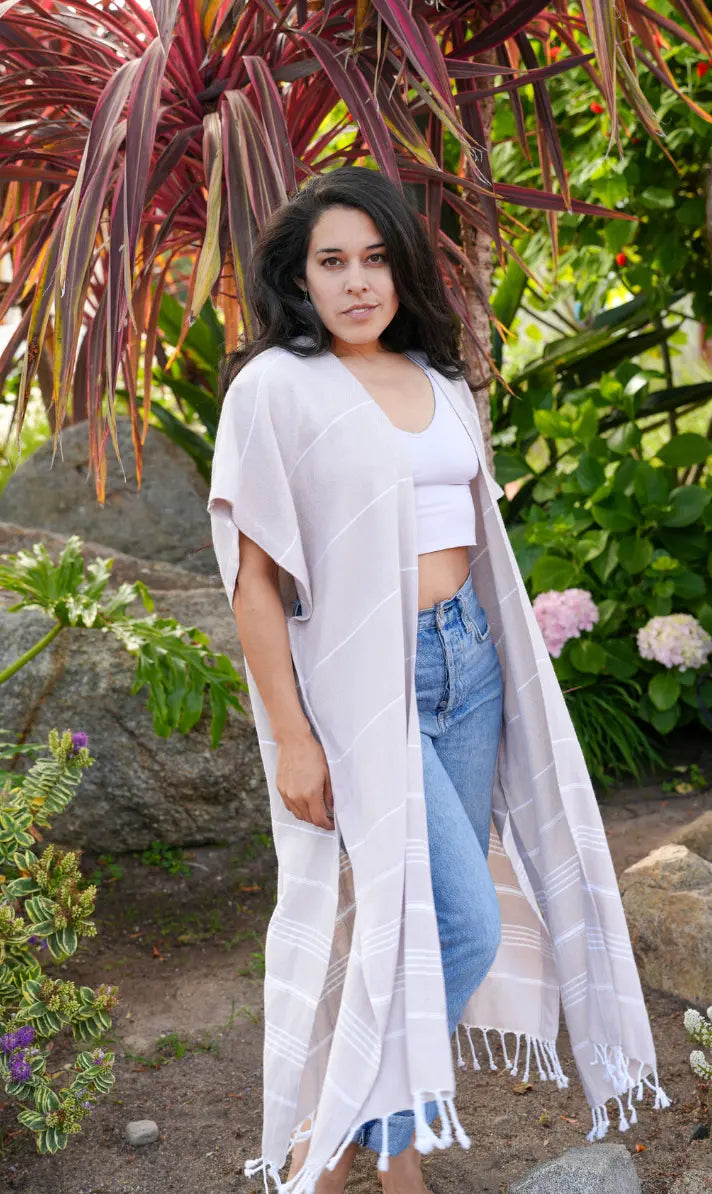 Woman wearing a beige striped kimono-style garment in a garden setting