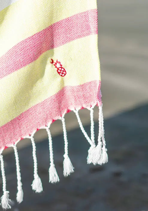 Red and yellow striped fabric close up of a red pineapple moon logo embroidery