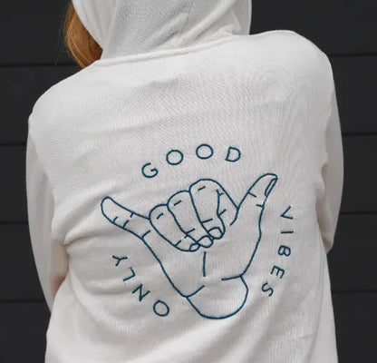 A white hoodie with 'GOOD VIBES' graphic embroidered on the back, featuring a hand making a hang loose sign.