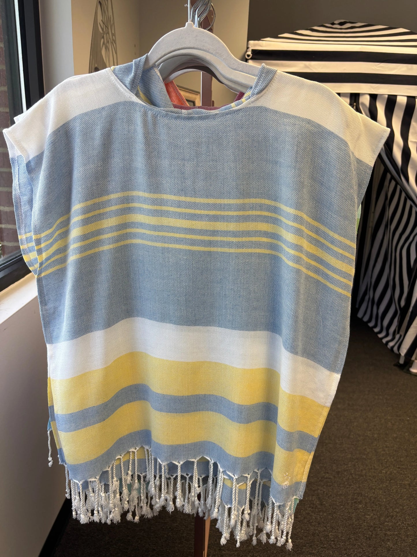 hooded poncho on a hanger with blue, yellow and white stripes