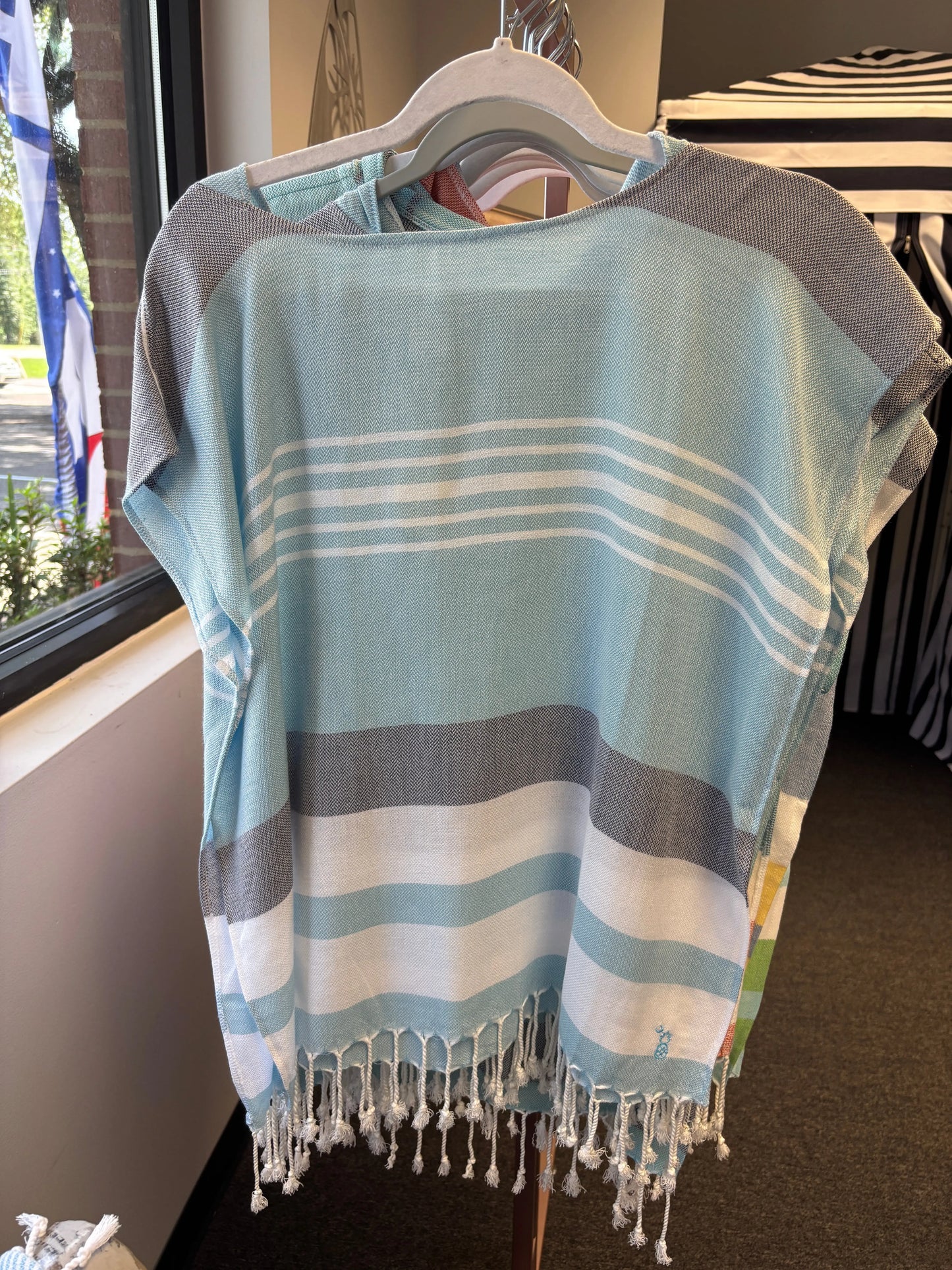 hooded poncho on a hanger with pale blue, charcoal and white stripes