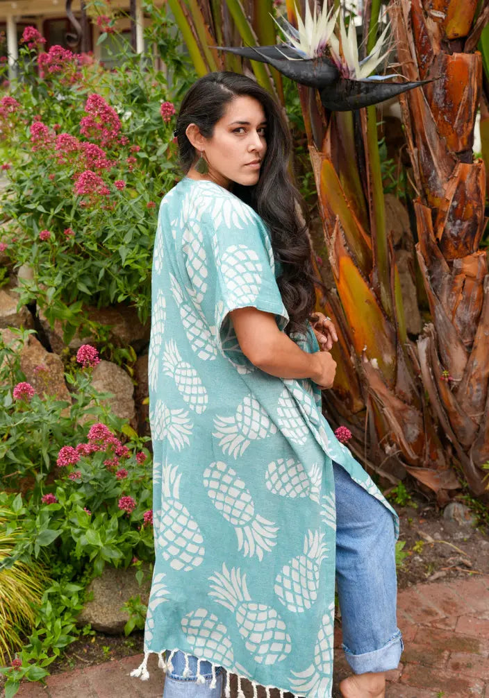 Woman wearing a green kimono with pineapple patterns in a garden setting