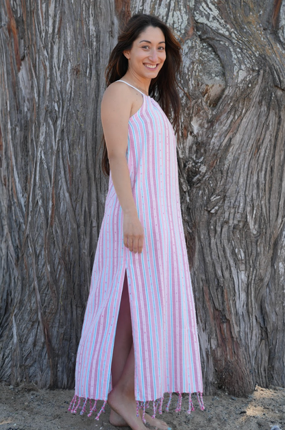 woman wearing pink striped sleeveless maxi sundress with tassels in front of tree