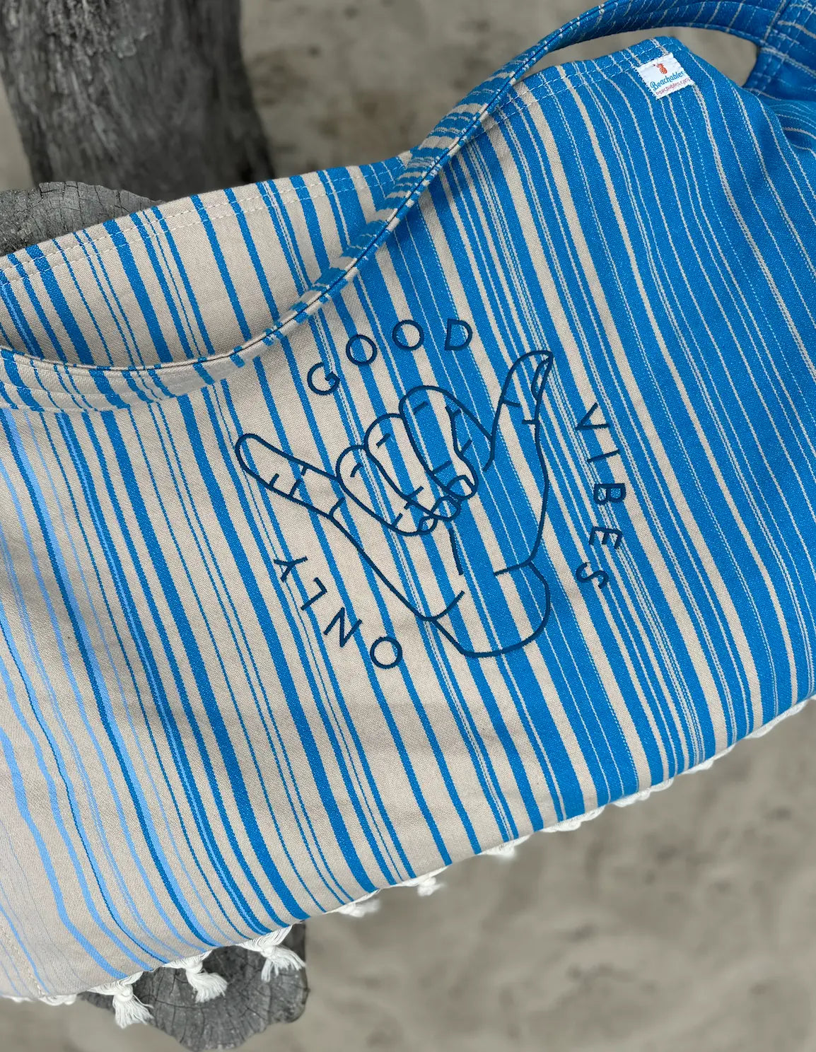 Blue and white striped bag with a graphic design on a textured surface