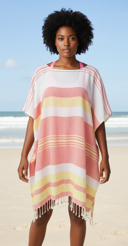 Woman wearing a red, yellow and white striped beach cover-up on a sandy beach with ocean view