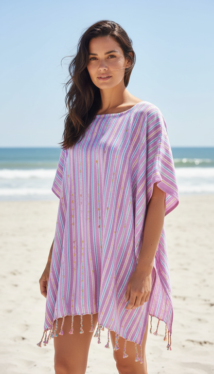 Woman wearing a pink striped beach cover-up on a sandy beach with ocean view