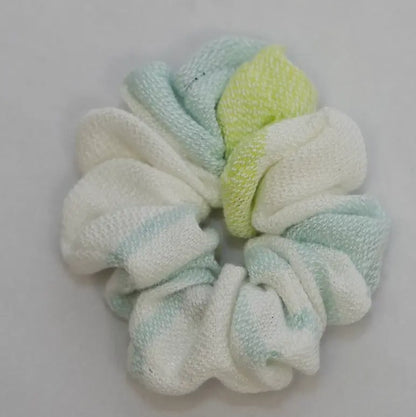 Textured scrunchie in light green and white on a gray background