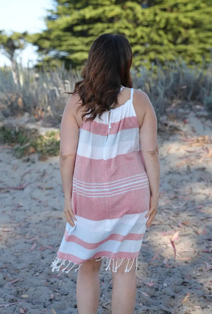 Back View of a Woman on beach wearing a sleeveless red, blue and white striped cover-up with tassels