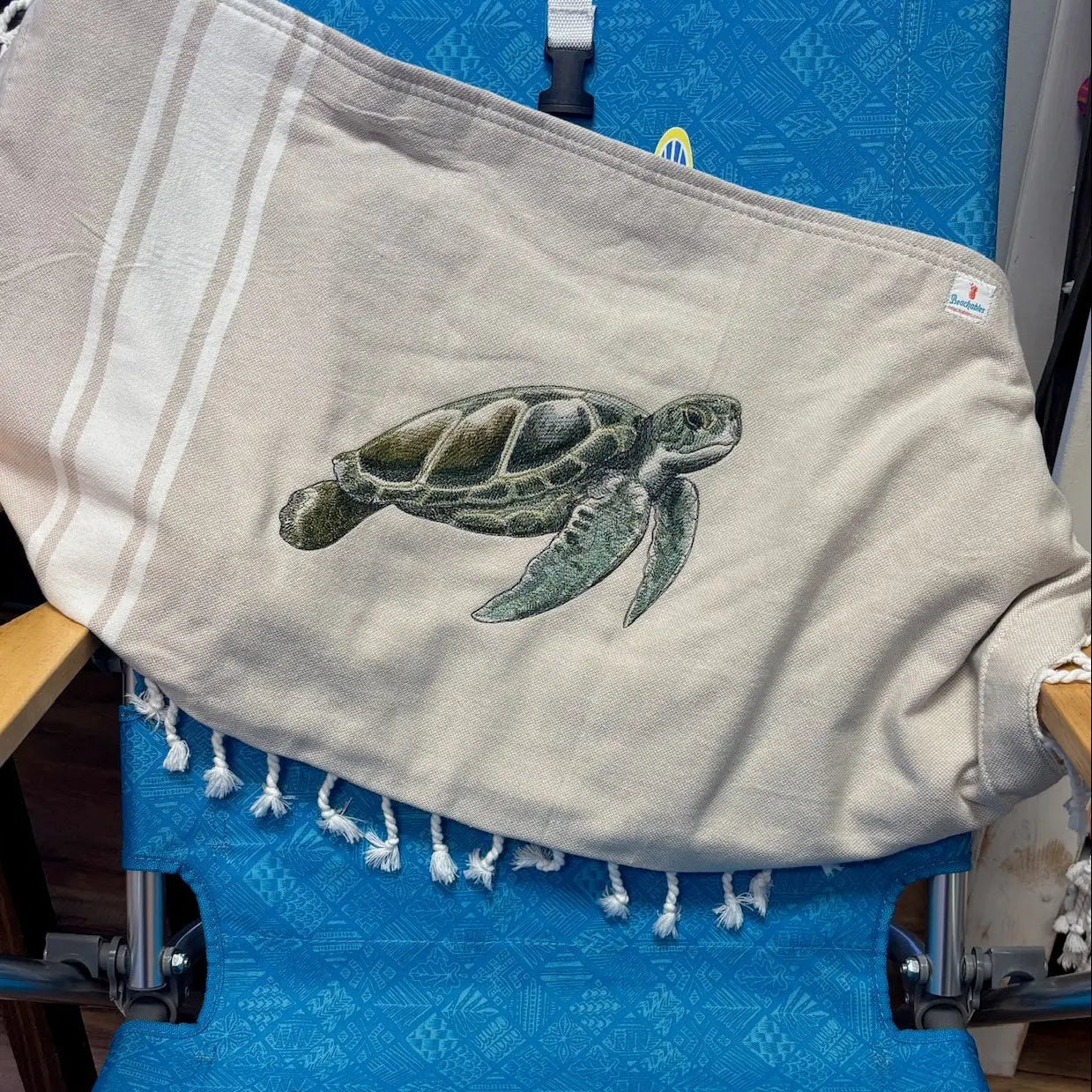 Beige bag with a turtle design on a blue chair